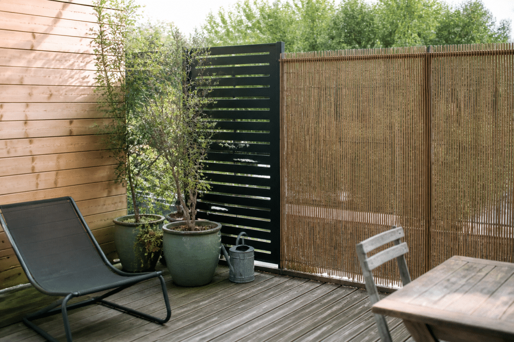 Terrasse avec panneaux bois, canisses bambou et claustra aluminium