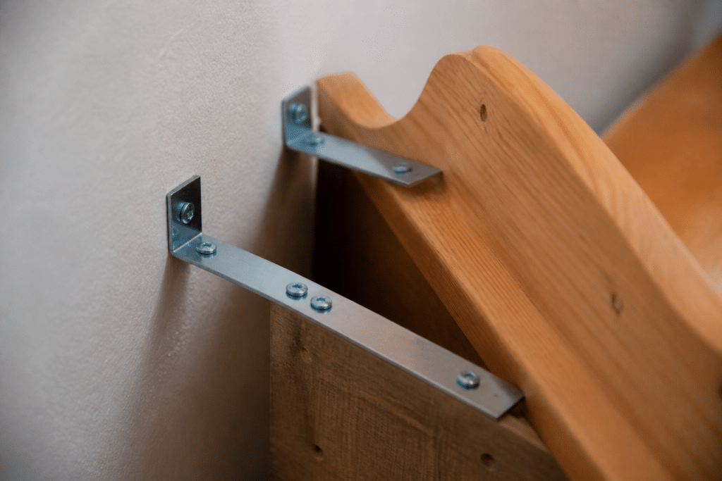 Deux equerres metalliques fixant tete de lit au mur