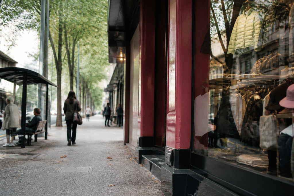 Rue commerçante avec magasins et arrêt de bus visible