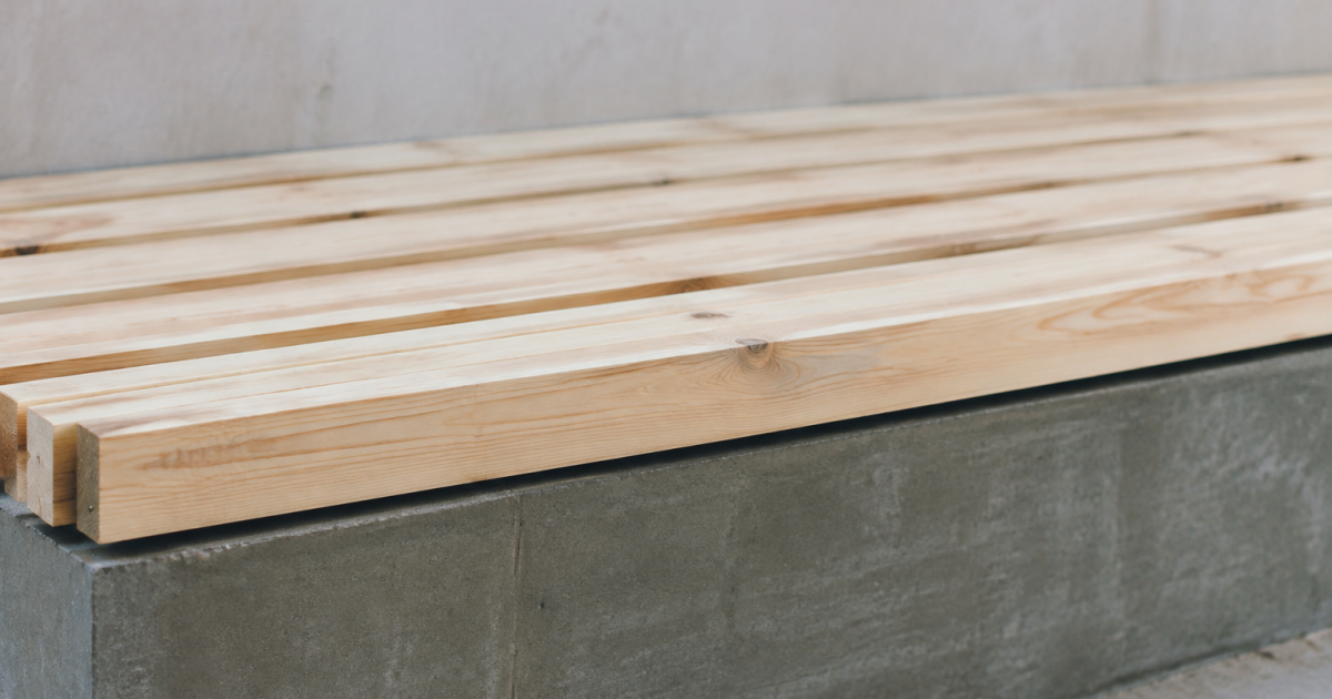 Planches bois blondes alignees horizontalement sur socle gris ciment