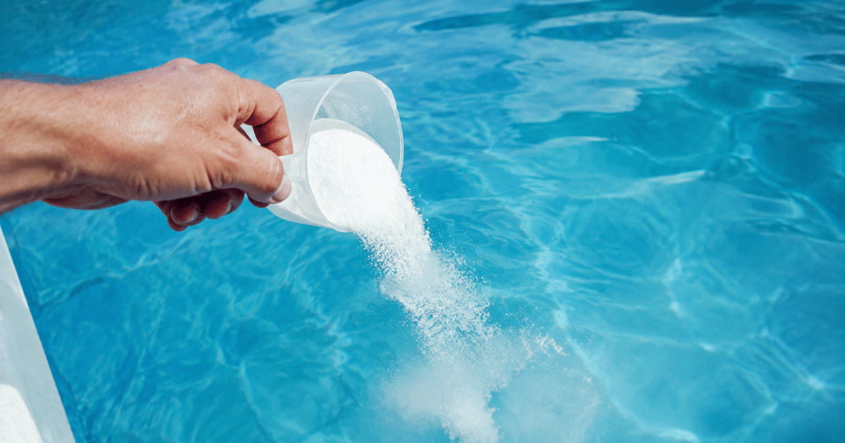 Main versant poudre blanche dans eau de piscine bleue