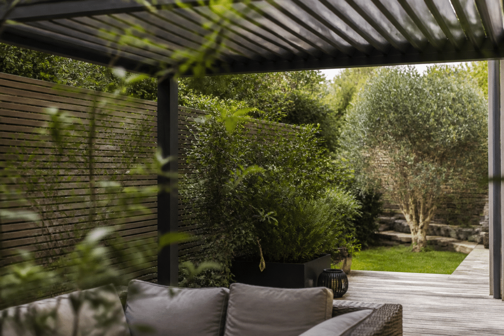 Terrasse protégée par claustra, haie et pergola superposées