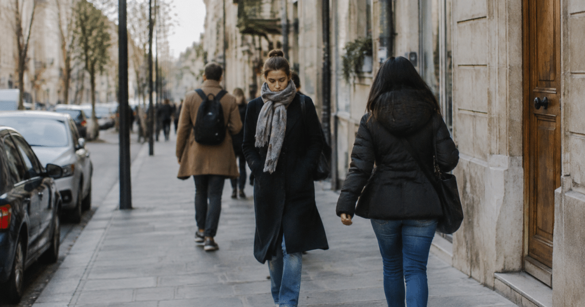 Rue urbaine avec immeubles et habitants marchant sur trottoir