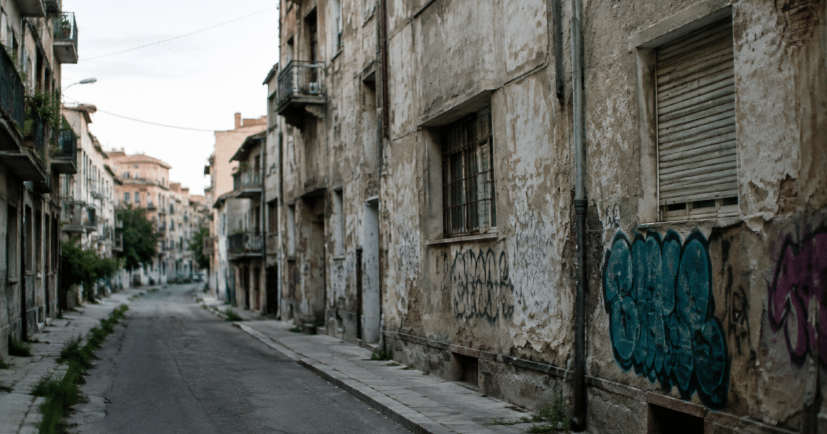 rue vide avec immeubles degrades et graffitis visibles